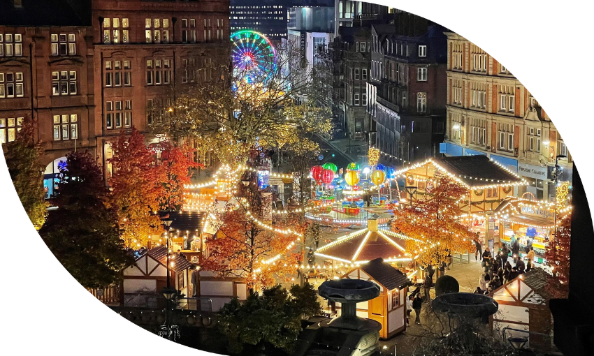 View over the Sheffield Peace Gardens at Christmas time, lit up by illuminations and rides