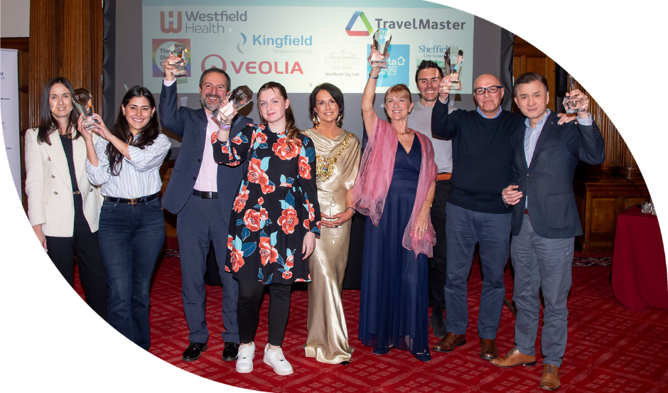 The Lord Mayor is surrounded by award winners holding their trophies in the air at the Lord Mayor Awards ceremony